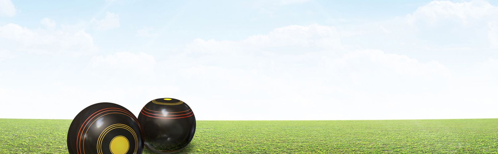 Lawn bowls on green grass with blue skies