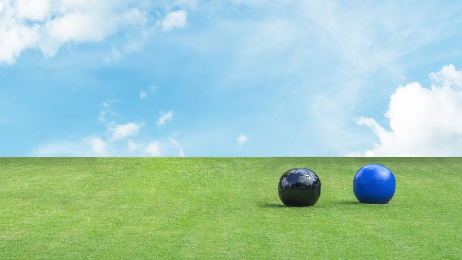 Lawn bowls on grass with blue skies