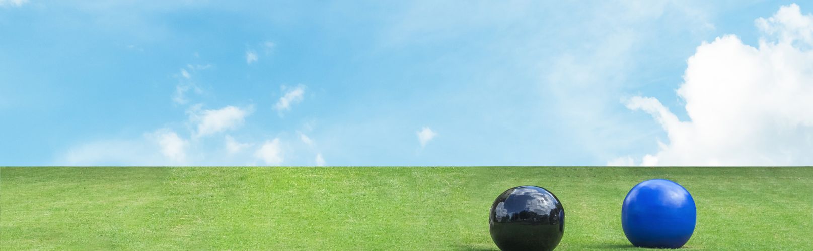Lawn bowls on green grass and blue skies