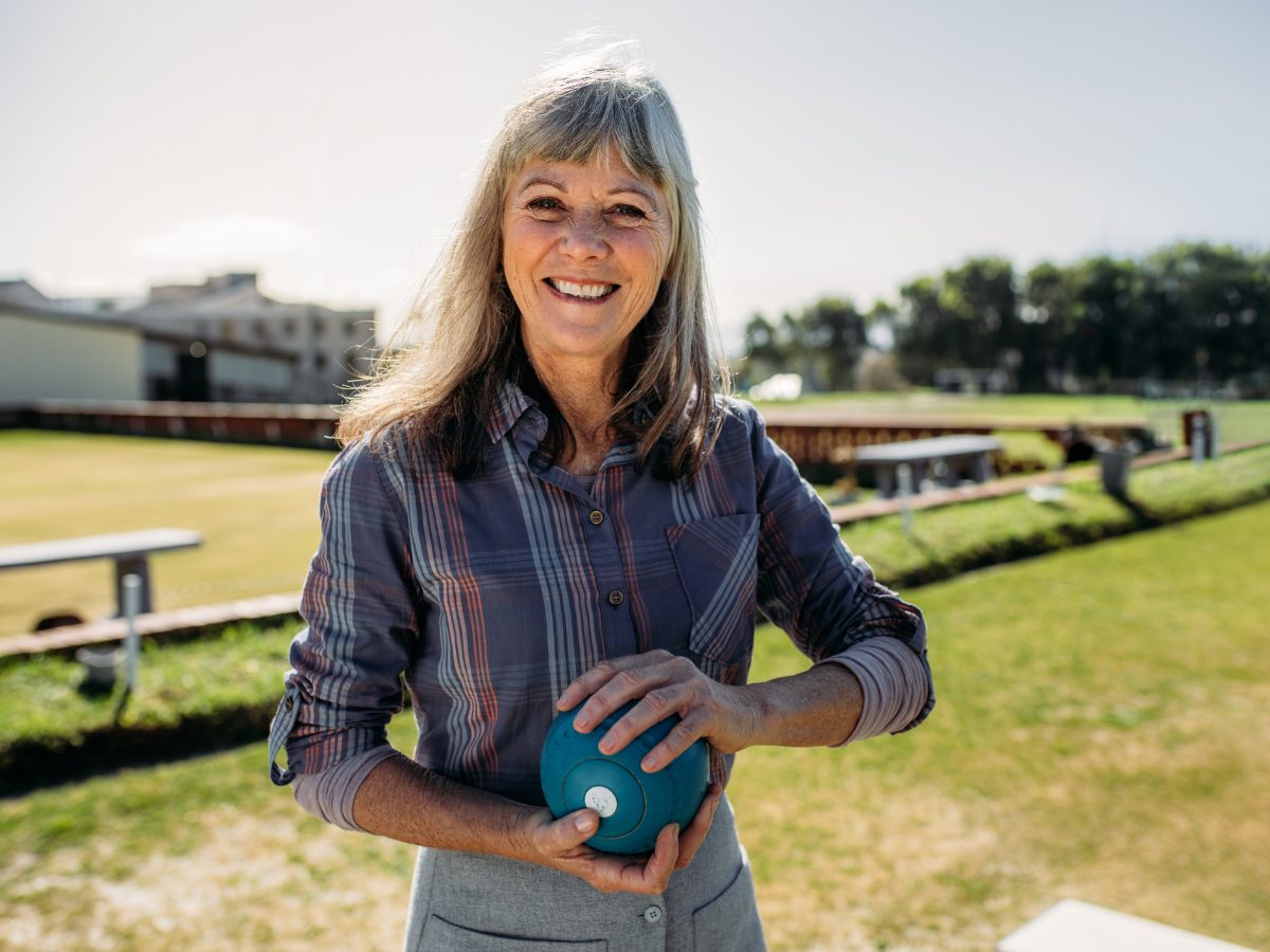 Lawn bowling player smiling with bowl in hand