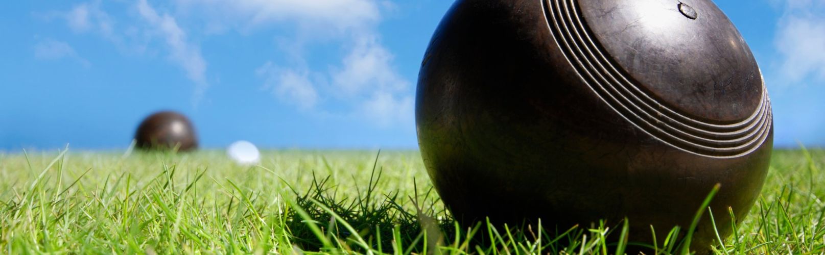 Lawn bowls on grass with blue skies
